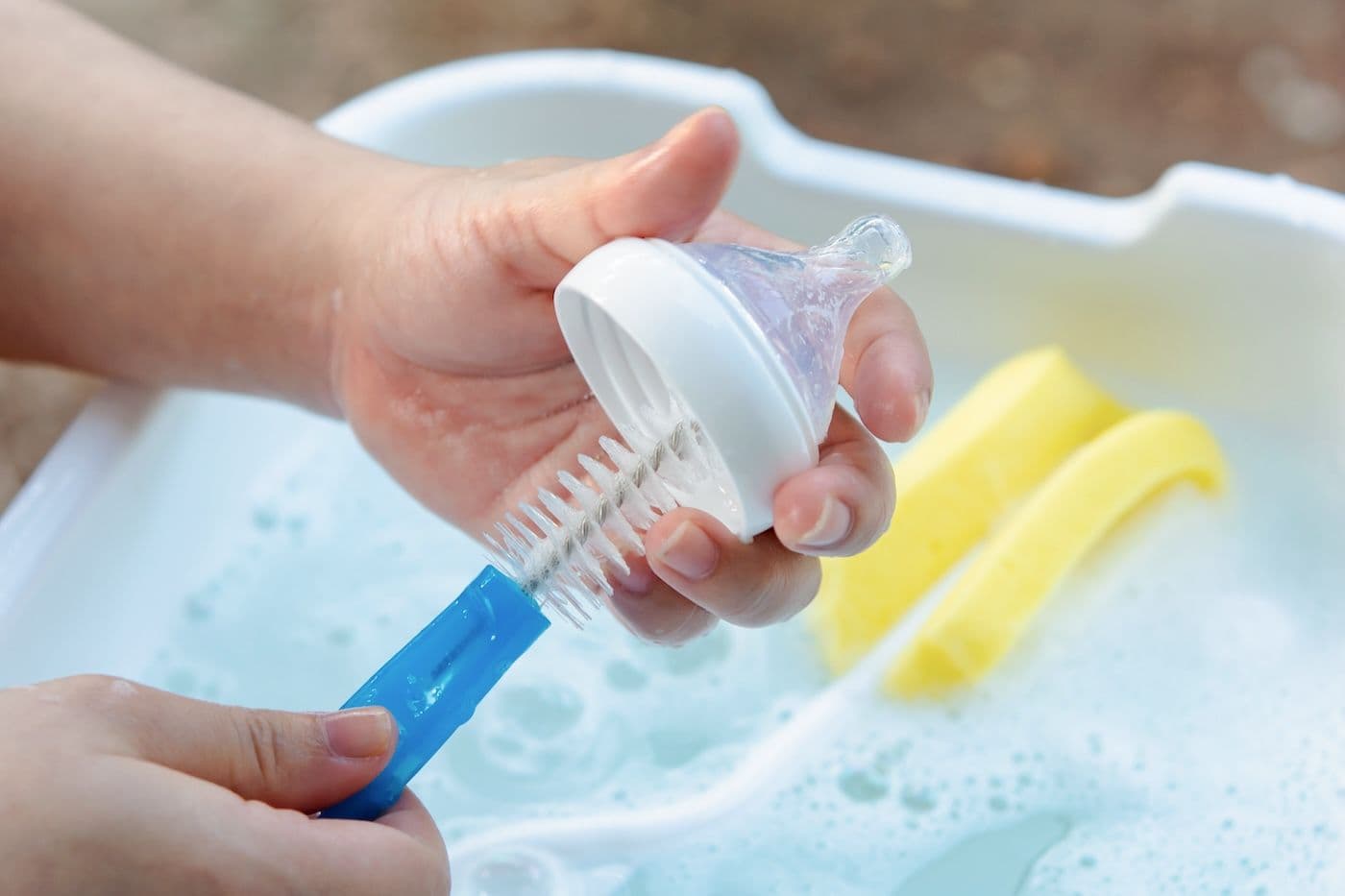 A parent cleans a baby bottle