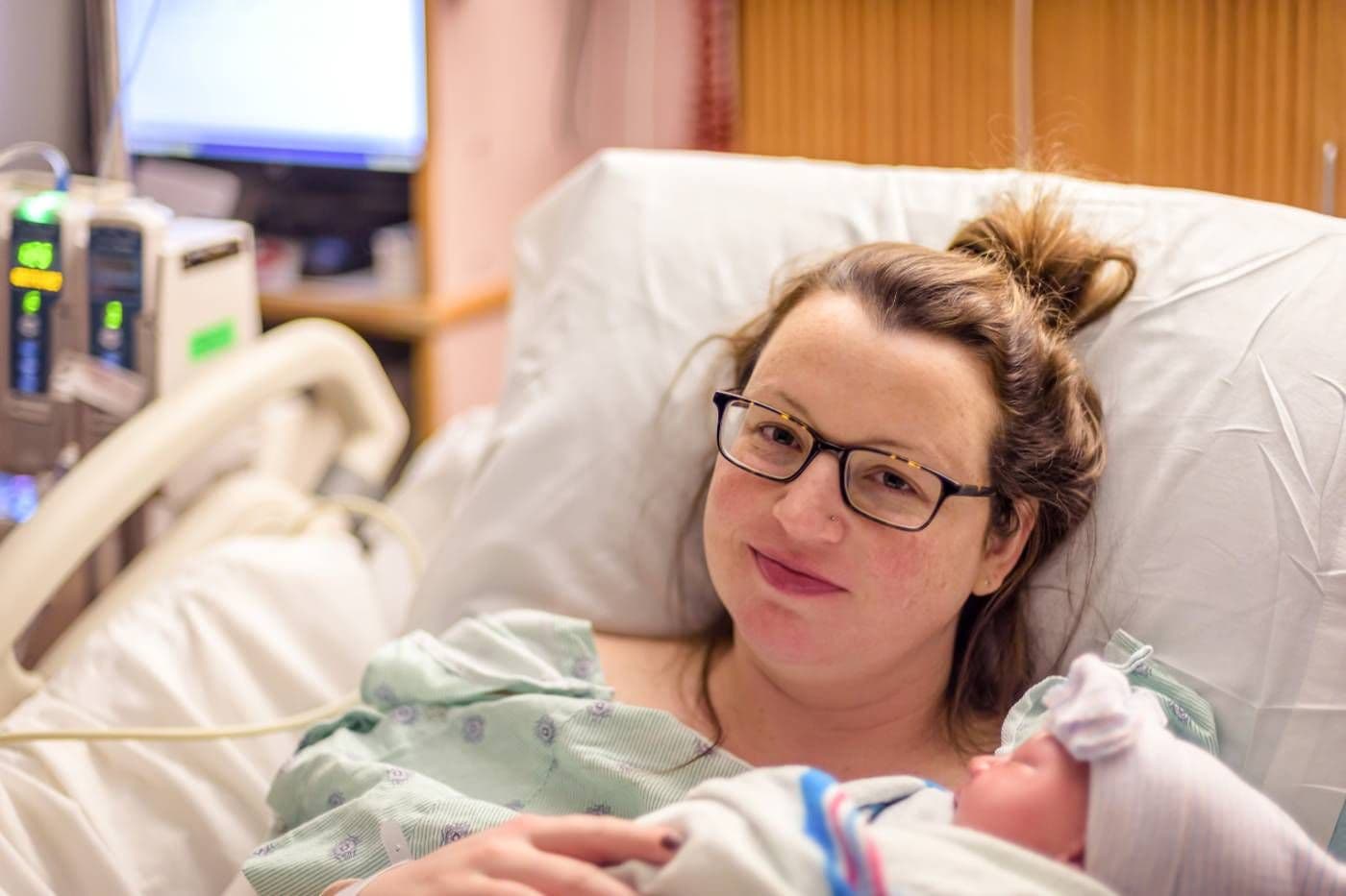 postpartum recovery: mother holding newborn in hospital